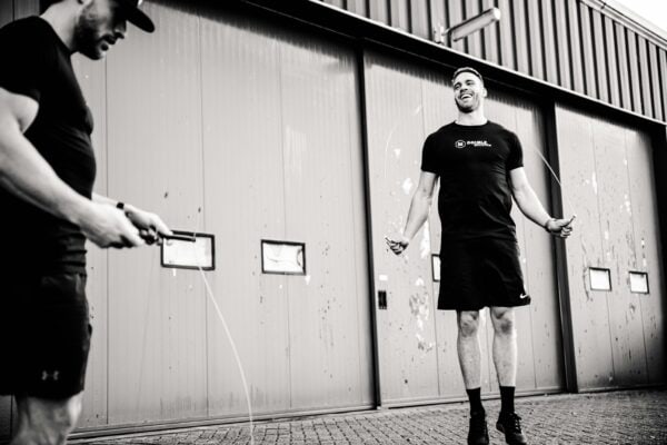 speed rope gebruik voor Crossfit door twee mannelijke atleten. Eén van de atleten doet double anders, de ander heeft een speed rope vast