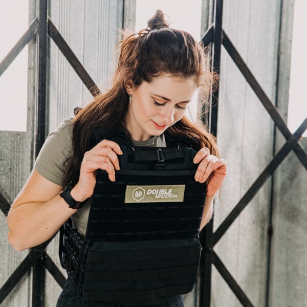 gewichtsvest in de kleur zwart en het gewicht van 9kg voorzien van de doubleunders patch en gedragen door een vrouwelijke crossfitter