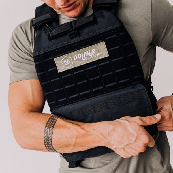 gewichtsvest van 9kg in de kleur zwart en met de doubleunders patch, die wordt vastgemaakt door een man